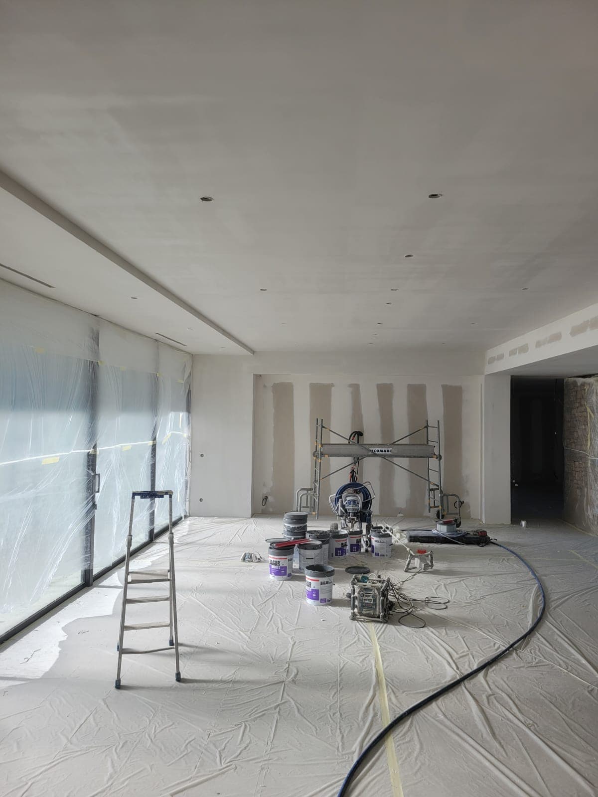 Vaste séjour en cours de mise en peinture, plafond et murs préparés par Belin Travaux