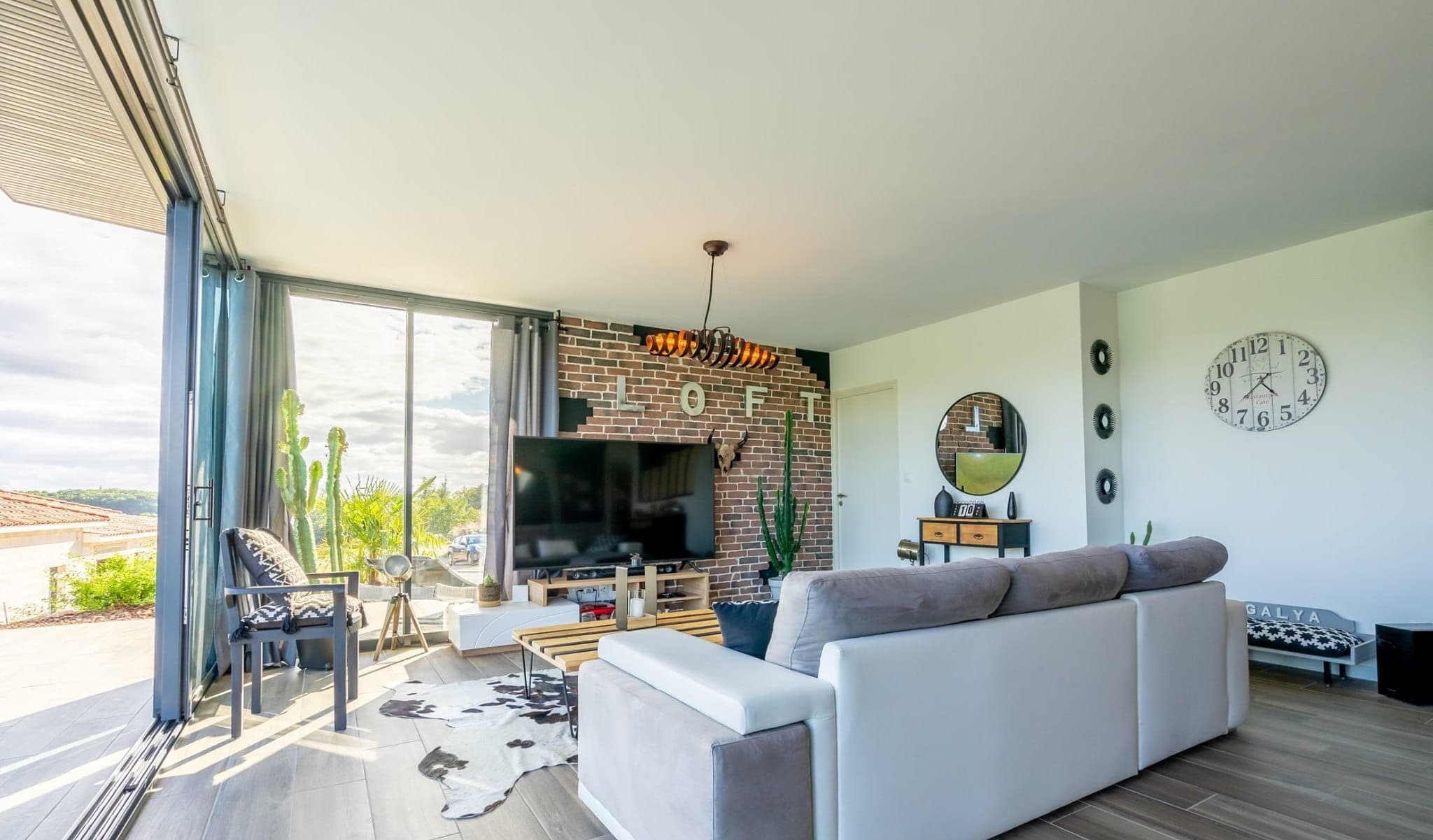 Rénovation d'un salon esprit loft avec mur en briques par Belin Travaux, secteur toulousain